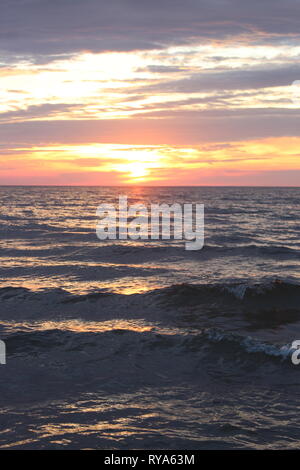 Increspato le acque possono essere divertente da Wade in al tramonto, basta assicurarsi che stai indossando i vestiti giusti- e non dimenticate di ammirare la vista. Foto Stock