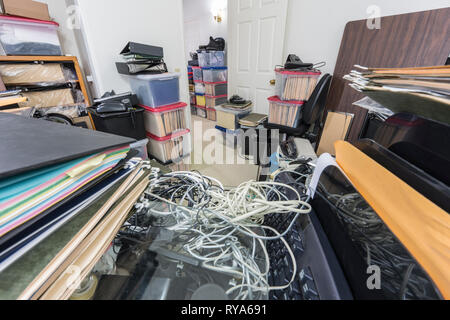 Confuso di back office desk con i file, caselle, il disordine, vecchie attrezzature e stoccaggio di merci varie. Foto Stock