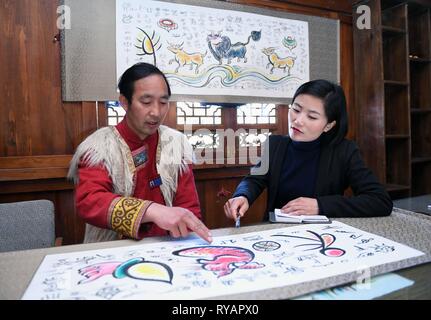 Pechino, Cina nella provincia dello Yunnan. Xiii Febbraio, 2019. Yongzhen ventola (R), un sostituto per il XIII congresso nazionale del popolo (ANP), effettua una ricerca sui Dongba lingua pittografica Yushuizhai al villaggio di Yulong Naxi contea autonoma a Lijiang, a sud-ovest della Cina di Provincia di Yunnan, Feb 13, 2019. Credito: Yang Zongyou/Xinhua/Alamy Live News Foto Stock