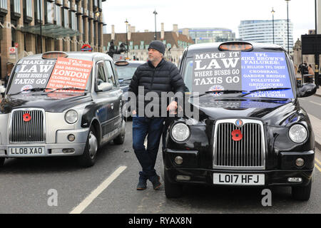 Westminster, Londra, Regno Unito, 13 Mar 2019. Un tassista si appoggia su un taxi nero. Black Cab Sciopero autotrasportatori ancora una volta in Westminster, bloccare diverse strade attorno a Westminster Bridge, la piazza del Parlamento e di Whitehall a protestare per ostacolare le restrizioni per i loro diritti di guidare nella corsia di circolazione degli autobus. Credito: Imageplotter/Alamy Live News Foto Stock