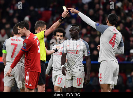 Monaco di Baviera, Germania. 13 Mar, 2019. Calcio: Champions League, knockout tondi tondi di sedici, seconda gamba: FC Bayern Munich - Liverpool FC di Allianz Arena. Arbitro italiano Daniele Orsato (l) mostra di Liverpool Officina Fabinho (non raffigurata) la scheda gialla. Credito: Pietro Kneffel/dpa/Alamy Live News Foto Stock