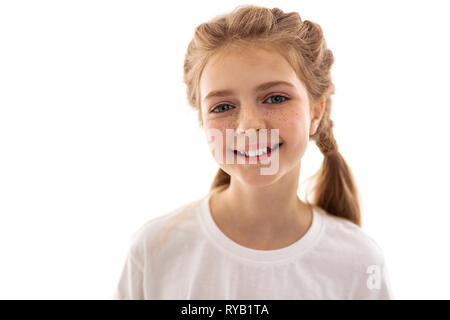 Attraente ragazza in piedi in una luce brillante e sorridente Foto Stock