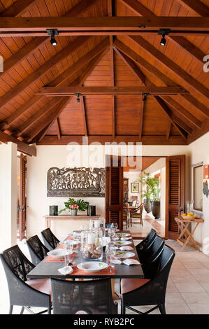 'Set tavolo da pranzo sotto il soffitto a travi in Tamarind Cove, Antigua' Foto Stock