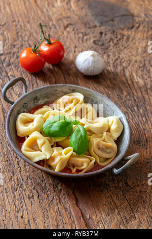 Tortellini su legno con salsa di pomodoro Foto Stock