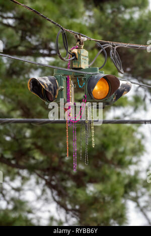 SHREVEPORT, LA., U.S.A. - 8 Marzo 2019: Mardi Gras beads gettato da galleggianti durante una parata decorare un segnale stradale. Foto Stock