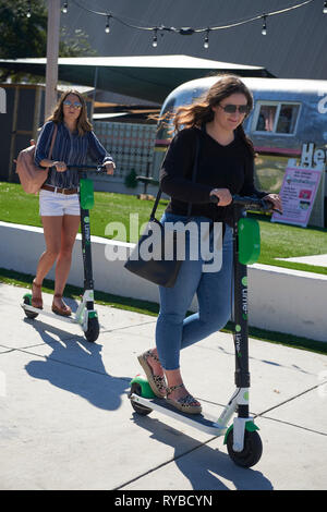 Donne Equitazione elettrico e scooter a noleggio, South Congress Avenue, Austin, Texas Foto Stock