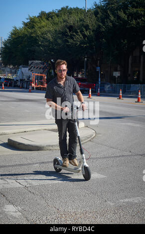 Un uomo che cavalca un elettrico e scooter a noleggio South Congress Avenue, Austin, Texas Foto Stock