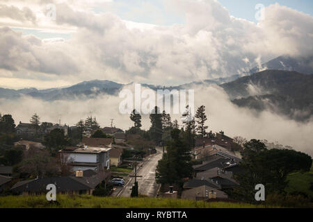 Nuvole drammatico aumento oltre il sonnolento quartiere suburbano in colline di sunrise Foto Stock