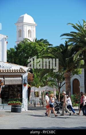 CONIL DE LA FRONTERA, Spagna - 14 settembre 2008 - turisti attraversando la strada nella città vecchia con la chiesa di Santa Catalina torre al posteriore, il Coni Foto Stock