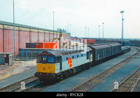 Una classe 33 Crompton locomotiva diesel serie 33207 e una classe 08 diesel numero derivatore 08542 condividono il compito di caricare contemporaneamente i rastrelli del carro sopra il linkspan e su 'Nord Pas-de-Calais' treno traghetto a Dover Western Docks. Xix Marzo 1993. Foto Stock