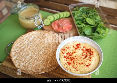 Una sana si avvolge con salmone e i ceci per pranzo. Amore per il cibo sano concetto Foto Stock