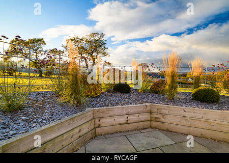 I colori autunnali nel bellissimo giardino privato, nello Yorkshire, Inghilterra, Regno Unito - design elegante e contemporaneo, hard landscaping & piantare legname in letti sollevata. Foto Stock