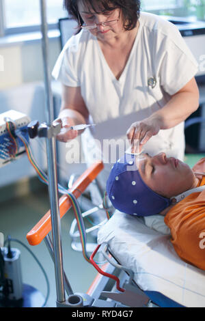 Giovane uomo durante esame elettroencefalografico Foto Stock