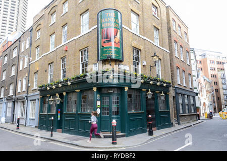 Un jogger di fronte alla casa pubblica di Hand e Shears su Middle Street, Smithfield, Londra, EC1, Regno Unito Foto Stock