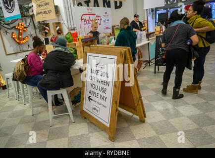 Pubblicità informa diners di uno sconto se si paga con la Apple paga il sistema di pagamento elettronico in Smorgasburg di Brooklyn a New York Sabato, 2 marzo 2019. (Â© Richard B. Levine) Foto Stock