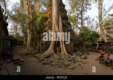 Famiglia visitando antiche Ta Prohm tempio di Angkor area archeologica in Cambogia Foto Stock
