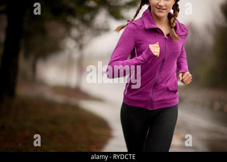 Young woman jogging on a residential street. Foto Stock
