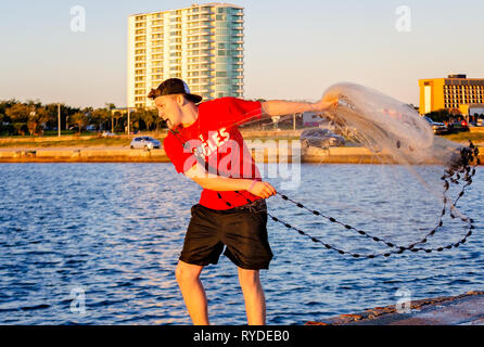 Un uomo getta un rombo liscio net presso il Broadwater Beach Marina, febbraio 24, 2019, in Biloxi Mississippi. Il resort è stato distrutto da un uragano Camille in 1969. Foto Stock