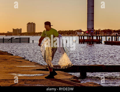 Un uomo getta un rombo liscio net presso il Broadwater Beach Marina, febbraio 24, 2019, in Biloxi Mississippi. Il resort è stato distrutto da un uragano Camille in 1969. Foto Stock