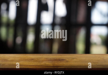 Vuoto in legno scuro tavolo di fronte abstract sfondo sfocato di ristorante, bar e coffee shop interno. può essere utilizzato per la visualizzazione o la vostra montage Foto Stock