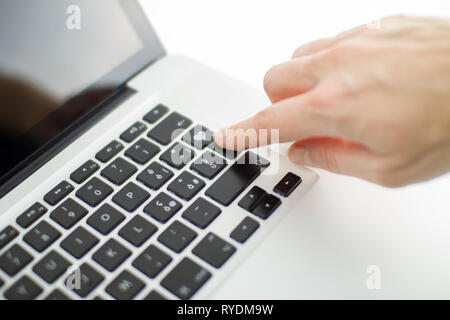Anche la tecnologia si applica ai rapporti affettivi: una donna di mano è circa alla pressione di un tasto sulla tastiera del notebook con un cuore impresso Foto Stock