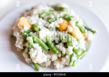 Macro closeup vista del risotto Arborio italiano riso cotto con lupino e fagioli verdi sulla piastra bianca Foto Stock