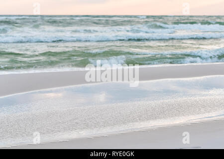 Trasognata rosa pastello giallo arancione tramonto a Santa Rosa Beach, Florida vicino alla costa di Pensacola in panhandle con ocean golfo del Messico onde e di primo piano Foto Stock