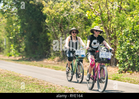 Sanibel Island, Stati Uniti d'America - 29 Aprile 2018: persone equitazione biciclette biciclette sul marciapiede sentiero nel Parco in spiaggia e la strada in Captiva Fort Myers, Florida Foto Stock