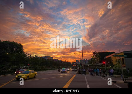 Incredibile Nuvola Rosa tramonto su Bukit Timah Road, con il traffico automobilistico - Singapore Foto Stock