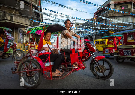 Amichevole triciclo filippino con conducente passeggero in Tacloban traffico, Leyte - Filippine Foto Stock