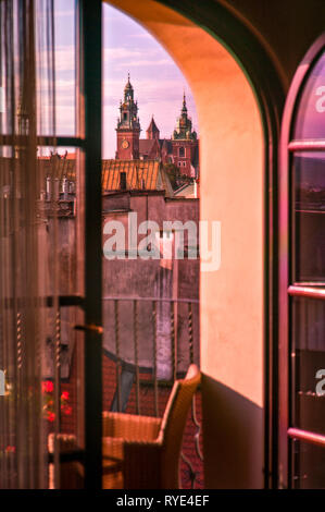 Paesaggio raffigurante lo skyline di Cracovia, in Polonia e in una chiesa al crepuscolo attraverso e la finestra aperta in estate Foto Stock