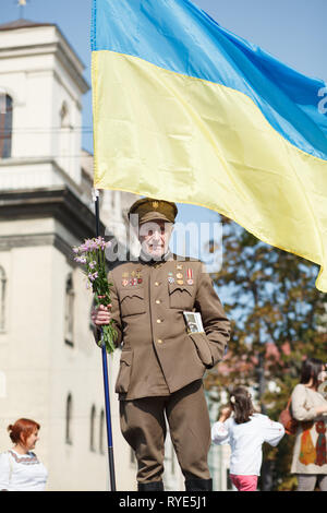 Lviv, Ucraina - 24 agosto 2017: un veterano dell'Ucraina esercito di insorti detiene una bandiera dell'Ucraina. Giorno di indipendenza dell'Ucraina Foto Stock