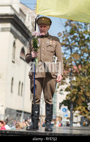 Lviv, Ucraina - 24 agosto 2017: un veterano dell'Ucraina esercito di insorti detiene una bandiera dell'Ucraina. Giorno di indipendenza dell'Ucraina Foto Stock