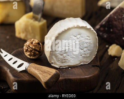 Fetta di formaggio caprino fresco sulla tavola di legno. Sfondo di formaggio. Foto Stock