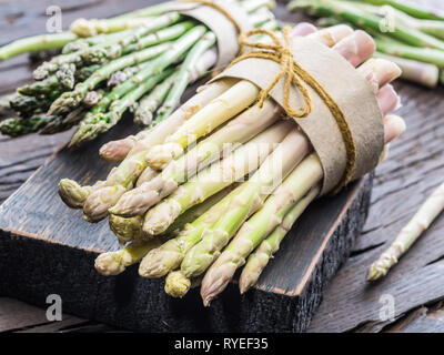 Fasci di verde e asparagi bianchi sulla tavola di legno. Alimenti biologici. Close-up. Foto Stock