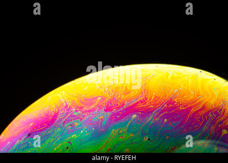 Abstract sfondo costituito da bolle di sapone che riflette la luce. Rainbow bolla di sapone su uno sfondo scuro. Foto Stock