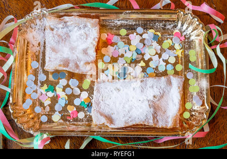 Composizione con tipici dolci di carnevale e colorati di coriandoli e stelle filanti come al solito in Italia Foto Stock