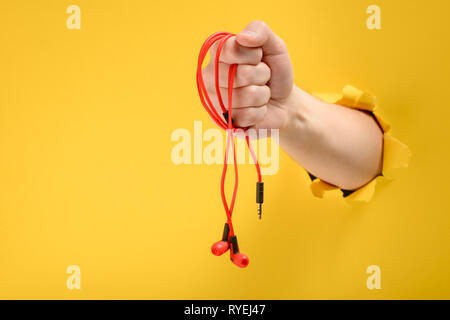 Mano azienda red cuffie auricolari Foto Stock