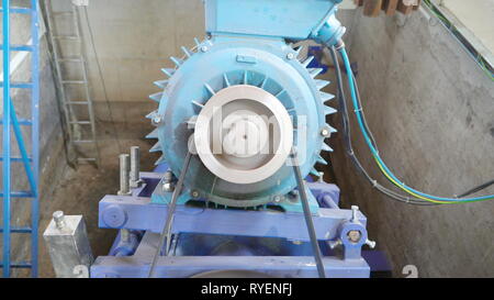 La rumorosa grande macchina idroelettrica all'interno della camera con la cintura bianca in esecuzione all'interno Foto Stock