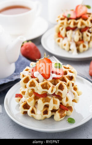 Waffles fatti in casa con fragole, la crema di latte e menta per dessert. Foto Stock