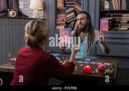 Bella buona Cerchi uomo parlando del libro Foto Stock