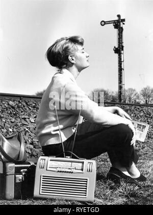 Broadcast, radio, apparecchi radio, Philips Annette LD471AB, una giovane donna è seduta con il suo bagaglio accanto a un terrapieno ferroviario, Germania, 1956, Additional-Rights-Clearance-Info-Not-Available Foto Stock