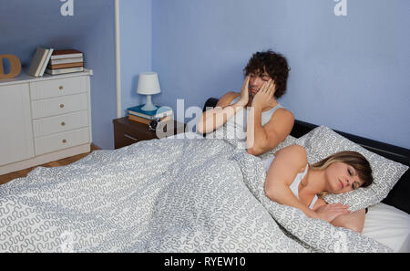 Uomo di svegliarvi mentre la moglie dorme Foto Stock