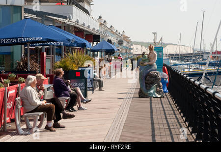 La gente seduta al di fuori di ristoranti a Brighton Marina, Sussex, Inghilterra. Foto Stock