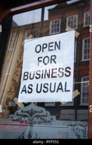 "Aperto per il business come di consueto" poster in una finestra. Foto Stock