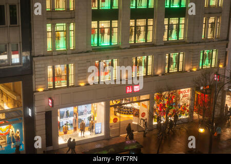 L'esterno dell'Uniqlo abbigliamento store su una notte piovosa in Oxford Street, Londra. Foto Stock