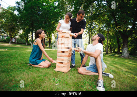 Amici a giocare gioco di bordo. Gigante esterna gioco di blocco. Gruppo gioco di abilità fisica con grandi blocchi. Foto Stock