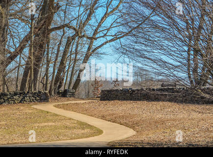 Marciapiede in curva che conduce attraverso il muro di pietra nella Brandywine Creek state park nel Delaware USA. Foto Stock