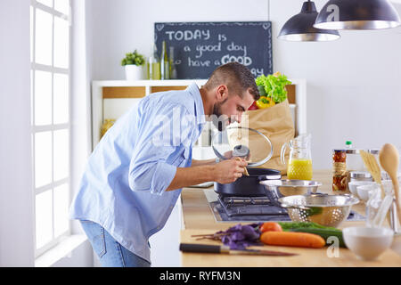 Sorridente e fiducioso chef in piedi in una grande degustazione di cucina un piatto cucinato Foto Stock