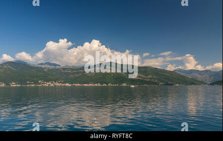 Piccoli villaggi turistici sulla Baia di Kotor in Montenegro, in una soleggiata giornata estiva. L'inizio della crociera da Tivat città. Foto Stock